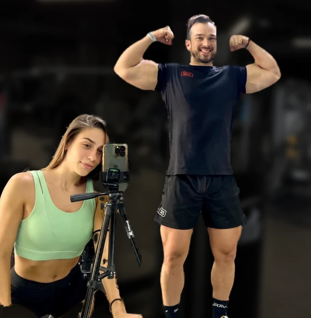 César y Rosa en la sala de CrossElite, César sacando bíceps y Rosa junto al trípode de grabación